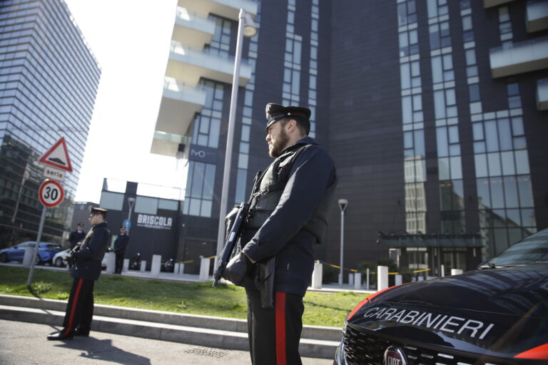 Italian Carabinieri police officers man a road block in Milan, Italy, Monday, March 16, 2020. Italy is on a nationwide lockdown to contain the COVID-19 virus outbreak. For most people, the new coronavirus causes only mild or moderate symptoms. For some it can cause more severe illness. (AP Photo/Luca Bruno)