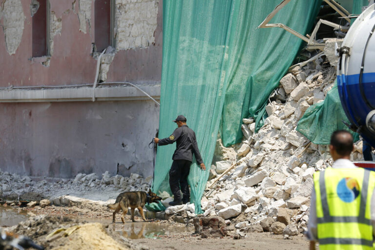 An Egyptian policeman with a sniffer dog checks the site of a Saturday explosion outside the Italian Consulate before a visit by the Italian Foreign Minister Paolo Gentiloni, in downtown, Cairo, Egypt, Monday, July 13, 2015. Gentiloni's visit comes days after a car bomb ripped into the Italian Consulate in Cairo early Saturday, destroying a section of the historic building in a powerful blast that killed one Egyptian and marked the most significant attack yet on foreign interests as militants target the country's security forces. (AP Photo/Hassan Ammar)