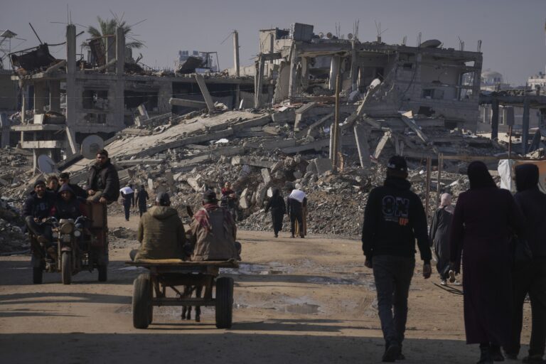 Palestinians carry UN donated flour in Khan Younis, central Gaza Strip, Saturday Dec. 14, 2024.(AP Photo/Abdel Kareem Hana)