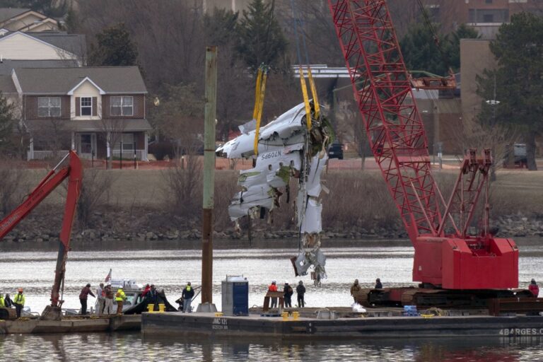 Rescue and salvage crews with cranes pull up the wreckage of an American Airlines jet in the Potomac River from Ronald Reagan Washington National Airport, Monday, Feb. 3, 2025, in Arlington, Va. (AP Photo/Jose Luis Magana)