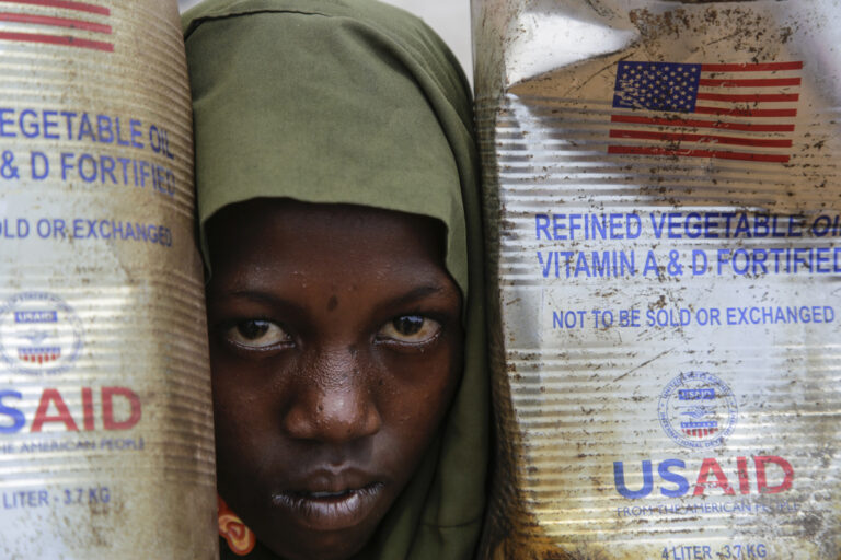 A Somali internally-displaced person (IDP) child looks out from her family's makeshift home in Maslah camp on the outskirts of Mogadishu, Somalia Wednesday, Feb. 5, 2025. (AP Photo/Farah Abdi Warsameh)