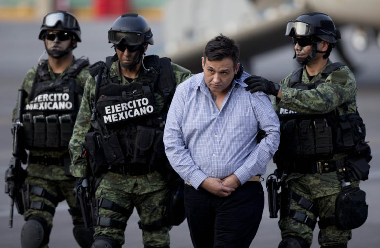 FILE - Soldiers escort a man who authorities identified as Omar Trevino Morales, alias "Z-42," leader of the Zetas drug cartel, as he is moved from a military plane to a military vehicle at the Attorney General's Office hangar in Mexico City, March 4, 2015. (AP Photo/Eduardo Verdugo, File)