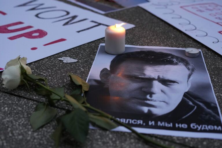 A lit candle burns by a picture of Russian opposition leader Alexei Navalny during a vigil in front of the Russian embassy in Lisbon, Friday, Feb. 16, 2024. Navalny, who crusaded against official corruption and staged massive anti-Kremlin protests as President Vladimir Putin's fiercest foe, died Friday in the Arctic penal colony where he was serving a 19-year sentence, Russia's prison agency said. He was 47. (AP Photo/Armando Franca)